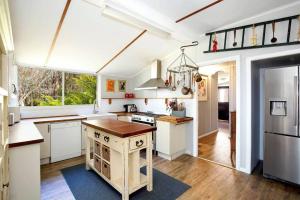 a kitchen with white cabinets and a large window at Allview Escape Blackheath in Blackheath