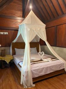 a bed with a canopy in a room at Java Turtle Lodge Meru Betiri in Banyuwangi