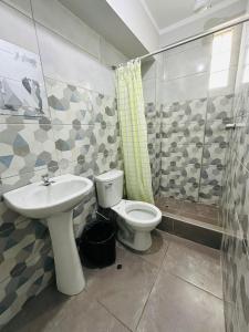 y baño con aseo, lavabo y ducha. en Yerupaja Mountain Hostel, en Huaraz
