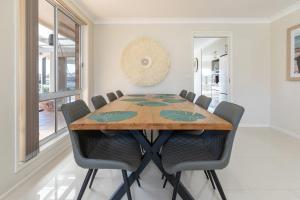 a dining room with a wooden table and chairs at 114 Elizabeth Pde in Forster