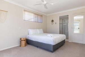 a bedroom with a bed and a ceiling fan at 114 Elizabeth Pde in Forster +10 photos
