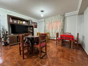 uma sala de jantar com uma mesa e cadeiras e uma televisão em Yerupaja Mountain Hostel em Huaraz