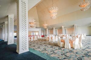a banquet hall with white chairs and tables and chandeliers at Ululani Bali in Bingin Beach
