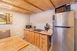 kuchnia z lodówką ze stali nierdzewnej i drewnianymi szafkami w obiekcie Montain Wild Chalet with Wooden Hot Tub 