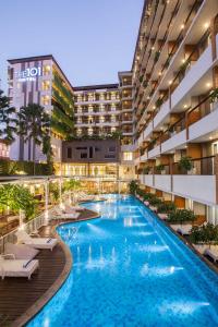 an image of a hotel pool with lounge chairs at THE 1O1 Yogyakarta Tugu in Yogyakarta