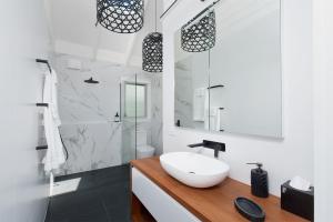 萨拉曼德湾Luxury Stay with Private Heated Pool in Salamander Bay的带白色水槽和淋浴的浴室