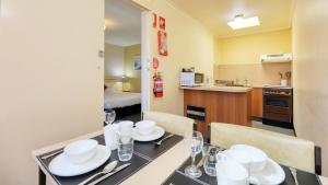 a dining room with a table with white dishes on it at Sunrise Devonport in Devonport