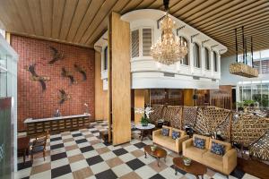 a lobby with couches and tables and a chandelier at THE 1O1 Yogyakarta Tugu in Yogyakarta