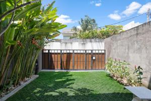 a backyard with a gate and grass at Ambara U6 Loft by Hombali in Canggu