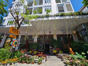 a building with a lot of flowers in front of it at MTR Apartment & Hotel in Da Nang