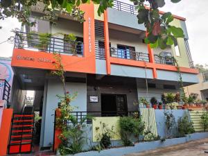 an orange and white building with a balcony at Rocky Homestay in Hampi