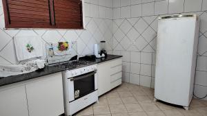 a kitchen with a stove and a refrigerator at Casa de Praia Iguape Ceará Paraíso in Aquiraz