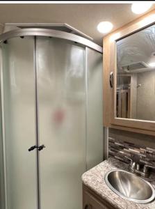 uma casa de banho com um chuveiro e um lavatório. em Private Cozy R/V , for your enjoyment em Tamiami