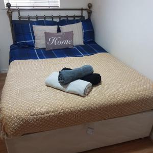 ein Bett mit zwei Handtüchern und einem Kissen darauf in der Unterkunft Kazo in Purfleet