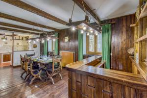 une salle à manger avec une table et des rideaux verts dans l'établissement Family Chalet In Monte Amiata - Happy Rentals, à Abbadia San Salvatore