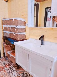 ein Badezimmer mit einem weißen Waschbecken und einem Spiegel in der Unterkunft Larita Đồi Cỏ Mơ in Hòa Bình
