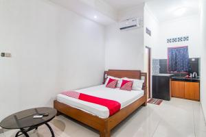 um quarto com uma cama e uma mesa em OYO 93691 Minongga em Jakarta