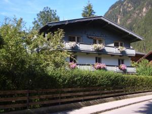 una casa con flores en los balcones de una montaña en Meckyheim, en Mayrhofen