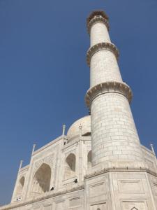 een minaret van een moskee tegen een blauwe lucht bij Hotel Taj Palace Agra in Agra