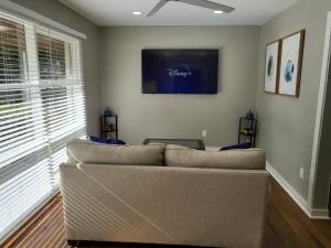 uma sala de estar com um sofá e uma televisão na parede em Rare Find! Private Heated Pool & Spa - Entire Home Near ATL City Center em Atlanta