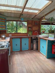 an outdoor kitchen with blue doors and a stove at La pirogue enchantée in Païta