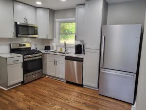 a kitchen with white cabinets and stainless steel appliances at Rare Find! Private Heated Pool & Spa - Entire Home Near ATL City Center in Atlanta
