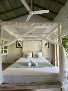 a bedroom with a canopy bed with two towels on it at Aurora in Unawatuna