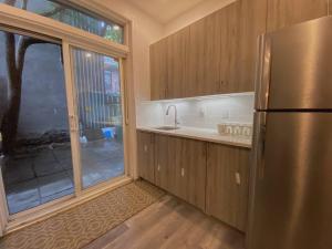 Il comprend une cuisine équipée d'un réfrigérateur en acier inoxydable et une fenêtre. dans l'établissement 4414-Modern 2 BD Gem/ near DT MTL, Canal, Atwater, à Montréal