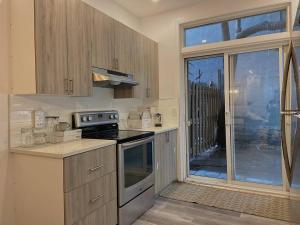 蒙特婁的住宿－4414-Modern 2 BD Gem/ near DT MTL, Canal, Atwater，一间带炉灶的厨房 窗边的顶部烤箱