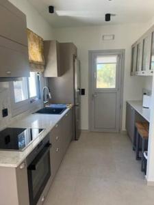 a large kitchen with a sink and a refrigerator at Villa del Sol in Pesádha +6 photos