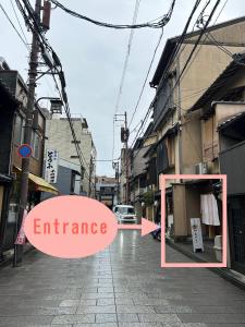une image d'une rue avec les mots entrée dans l'établissement Gion Kyoto Miyagawacyo Guesthouse HANAKANZASHI, à Kyoto