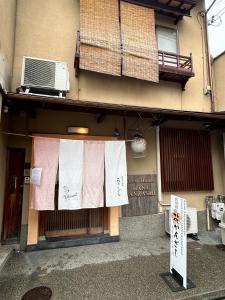 - un bâtiment avec des serviettes suspendues devant dans l'établissement Gion Kyoto Miyagawacyo Guesthouse HANAKANZASHI, à Kyoto