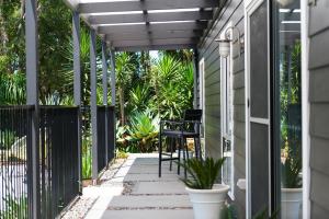Luxury Stay with Private Heated Pool in Salamander Bay في سالاماندر باي: فناء مع طاولة وكراسي على منزل
