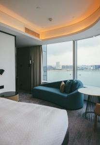 Four Points by Sheraton Hong Kong, Tung Chung في هونغ كونغ: غرفة فندقية بسرير ونافذة كبيرة