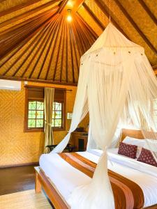 a bedroom with two beds with mosquito nets at Atres Villa in Munduk