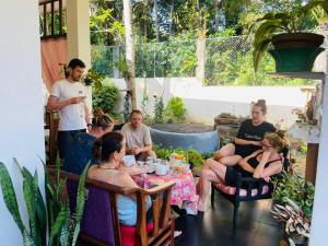 un grupo de personas sentadas alrededor de una mesa en Villa kresilda, en Gampola