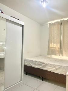 um pequeno quarto com uma cama e uma janela em Apartamento grande Florianópolis próximo arena opus em São José