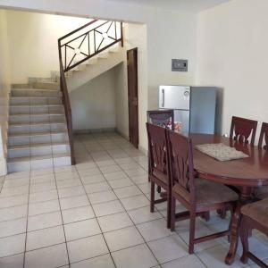 a dining room with a table and a staircase at Diani Breeze Villas in Diani Beach