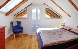 um quarto com uma cama e uma cadeira azul em 2 Bedroom Nice Home In Kolbnitz em Unterkolbnitz
