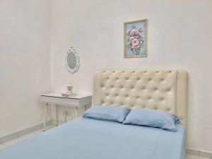 a bedroom with a large bed and a table at Homestay Gambang Modern vintage OZZY GUESTHOUSE in Gambang