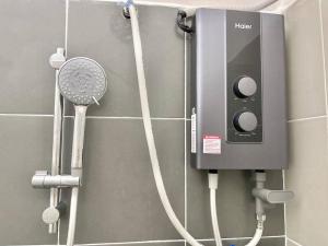 a bathroom with a shower with a hair dryer and a fan at Homestay Gambang Modern vintage OZZY GUESTHOUSE in Gambang