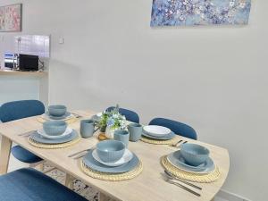 uma mesa de madeira com pratos azuis e cadeiras azuis em Homestay Gambang Modern vintage OZZY GUESTHOUSE em Gambang