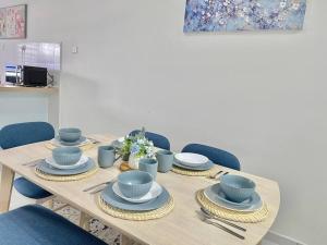 a wooden table with blue dishes and blue chairs at Homestay Gambang Modern vintage OZZY GUESTHOUSE in Gambang +24 photos