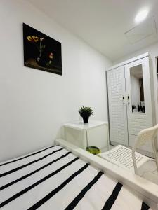 DSV Property في أبوظبي: غرفة بيضاء بسرير وكرسي