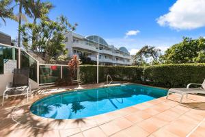 a swimming pool in front of a building at 5 "Sempre" 28-34 Duke St Sunshine Beach in Sunshine Beach
