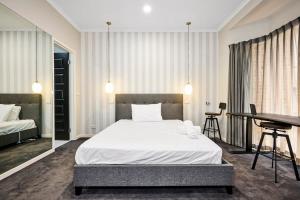 a bedroom with a bed and a desk and a table at Vibrant Townhouse Hideaway Balcony Bliss & Parking Paradise in Point Cook
