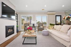 a living room with a couch and a fireplace at Vibrant Townhouse Hideaway Balcony Bliss & Parking Paradise in Point Cook