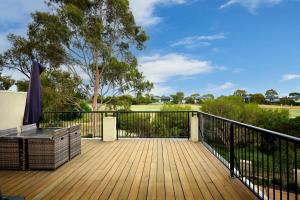 a wooden deck with a bench and a fence at Vibrant Townhouse Hideaway Balcony Bliss & Parking Paradise in Point Cook