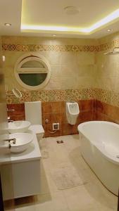 bagno con 2 lavandini, vasca e servizi igienici di المهمدسين a Il Cairo