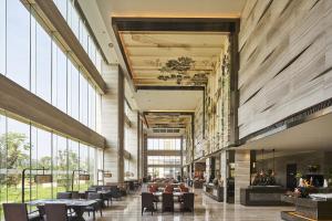 a lobby with tables and chairs and large windows at Sheraton Chuzhou Hotel in Chuzhou